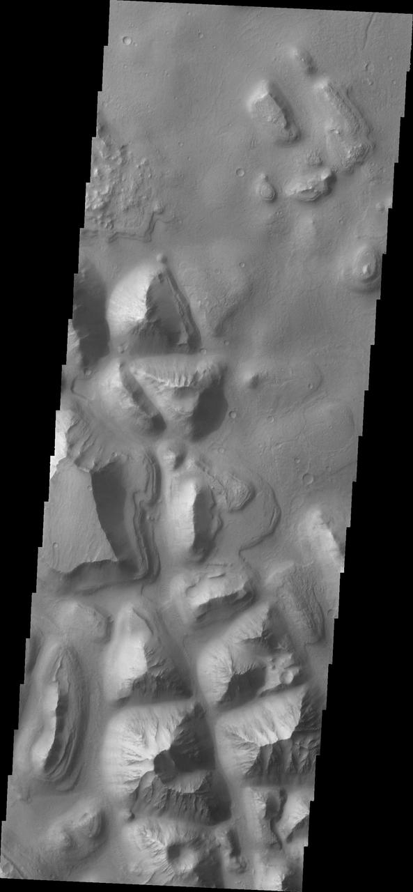 This image from NASA 2001 Mars Odyssey spacecraft shows a portion of Hydraotes Chaos. The individual hills on the left side of the image also appear to be layered.