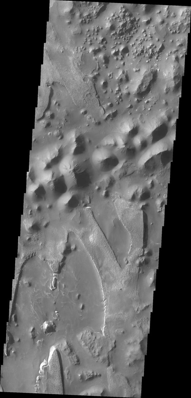The unusual and apparently layered surface in this image from NASA 2001 Mars Odyssey spacecraft is located in Aureum Chaos.