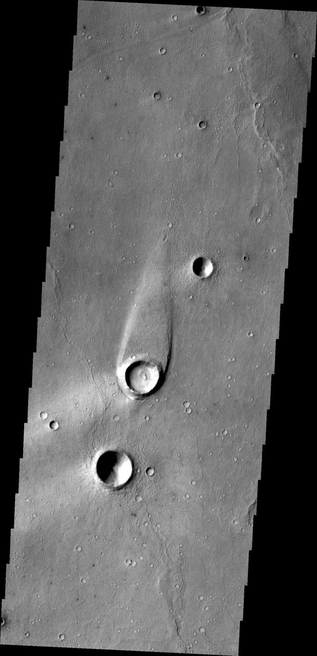 The streamlined island in this image from NASA 2001 Mars Odyssey spacecraft formed within the channel of Maja Valles. The flow of water was deflected by the crater leaving material in the lee of the crater.