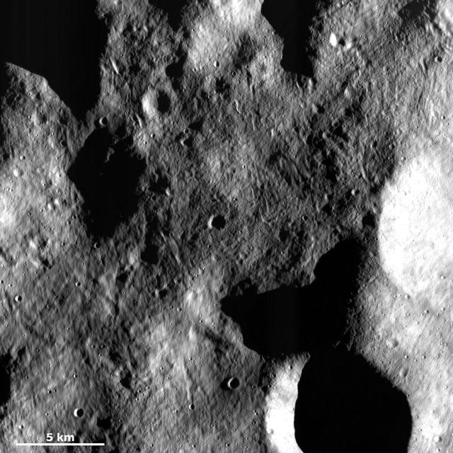 This image from NASA Dawn spacecraft of asteroid Vesta shows a part of the surface in Vesta northern hemisphere, which is scoured by many grooves with different orientations.