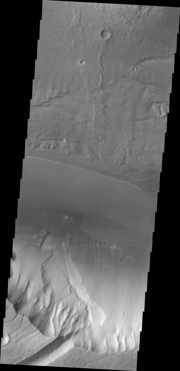 At the base of this slope is a fan-shaped deposit of the slope forming material. The channel that the fan rests upon is Kasei Valles in this image as seen by NASA 2001 Mars Odyssey spacecraft.
