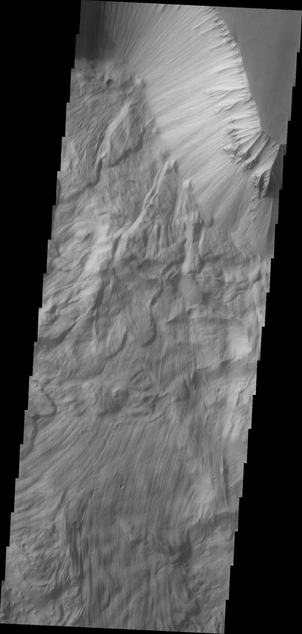 The massive, complex landslide deposits in this image from NASA 2001 Mars Odyssey spacecraft are located on the northern slope of Ophir Chasma.