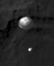 NASA Curiosity rover and its parachute were spotted by NASA Mars Reconnaissance Orbiter as Curiosity descended to the surface. The HiRISE camera captured this image of Curiosity while the orbiter was listening to transmissions from the rover.