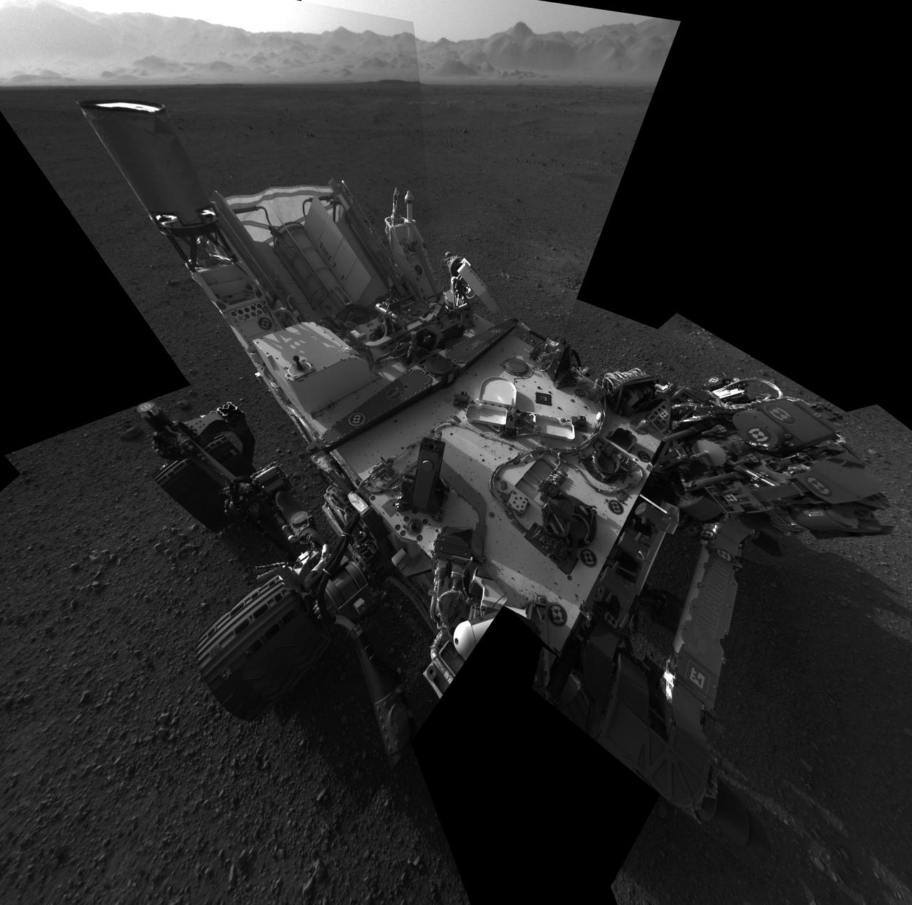 This full-resolution self-portrait shows the deck of NASA Curiosity rover. The back of the rover can be at top left, two of the right side wheels at left, and the undulating rim of Gale Crater forms the lighter color strip in the background.