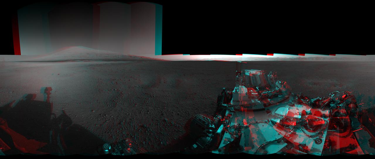 This 3D image from NASA Curiosity was taken from the rover Bradbury Landing site inside Gale Crater, Mars. Between the rover on the right, and its shadow on the left, looms the rover eventual target: Mount Sharp.