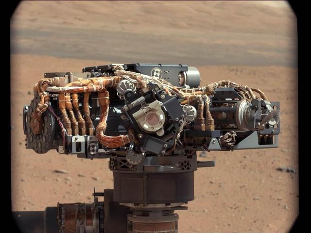 This image shows the Mars Hand Lens Imager MAHLI on NASA Curiosity rover, with the Martian landscape in the background. The image was taken by Curiosity Mast Camera on the 32nd Martian day, or sol, of operations on the surface.