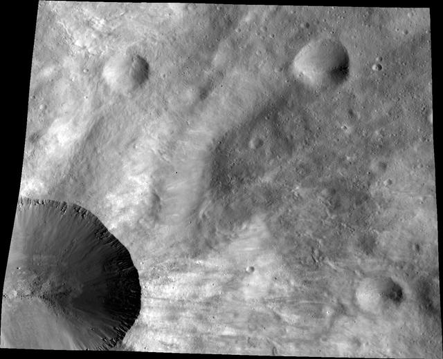 This image from NASA Dawn spacecraft shows a close up of part of the rim around the crater Canuleia on the giant asteroid Vesta. Canuleia, about 6 miles 10 kilometers in diameter, is the large crater at the bottom-left of this image.