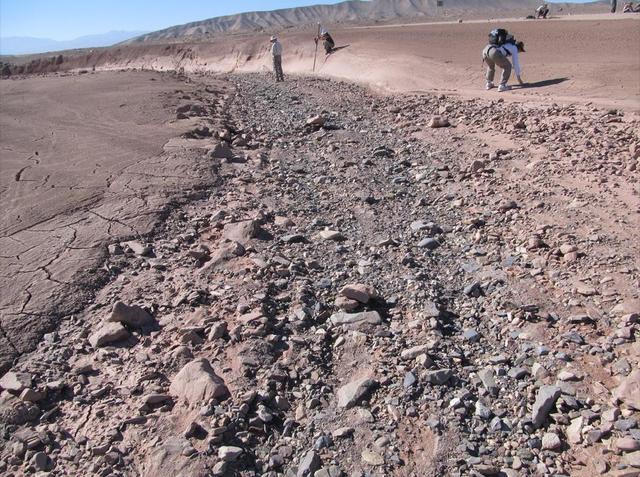 This image shows a dry streambed on an alluvial fan in the Atacama Desert, Chile, revealing the typical patchy, heterogeneous mixture of grain sizes deposited together.