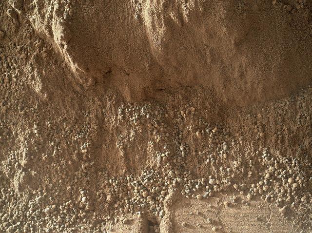This image shows the wall of a scuffmark NASA Curiosity made in a windblown ripple of Martian sand with its wheel. The upper half of the image shows a small portion of the side wall of the scuff and a little bit of the floor of the scuff.