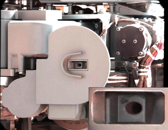 This image from NASA Curiosity rover just after discarding a soil sample as part of its first decontamination exercise. A small amount of remnant material is visible inside the delivery tube, which is magnified in the blow-up at lower right.