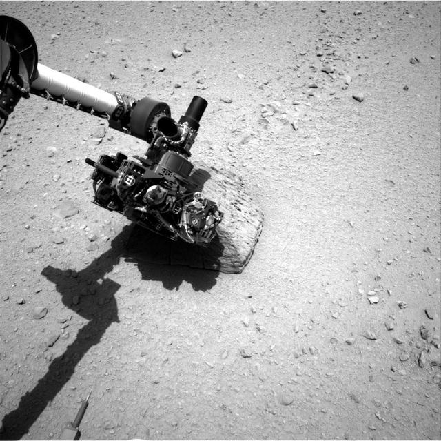 This image shows the robotic arm of NASA Mars rover Curiosity with the first rock touched by an instrument on the arm. The rover placed the APXS instrument onto the rock to assess what chemical elements were present in the rock.