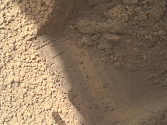 This image contributed to an interpretation by NASA Mars rover Curiosity science team that some of the bright particles on the ground near the rover are native Martian material.