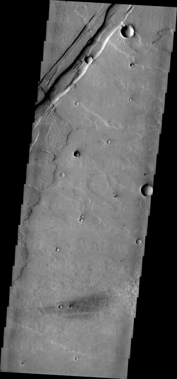 The parallel sides and low interior seen in this image from NASA 2001 Mars Odyssey spacecraft are faults and down-dropped material between the faults. This tectonic feature is called a graben. The graben in this image is located in Daedalia Planum.