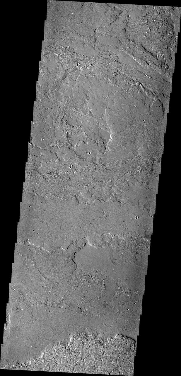 This image from NASA 2001 Mars Odyssey spacecraft shows some of the extensive volcanic flows east of the large Tharsis volcanoes.