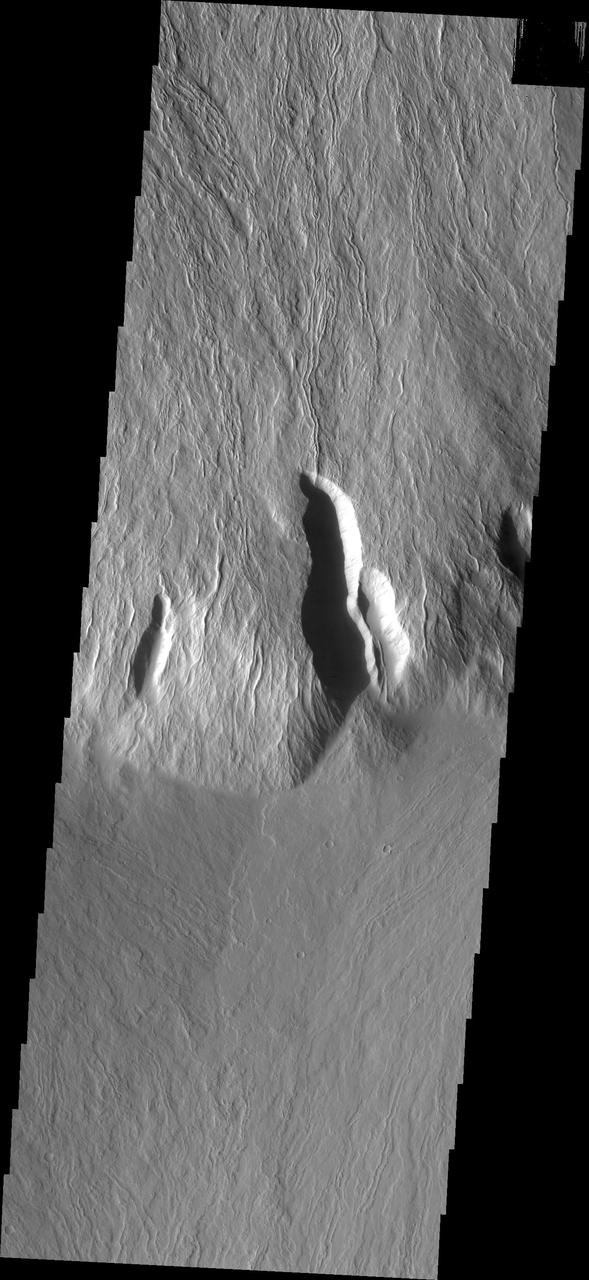 This image captured by NASA 2001 Mars Odyssey spacecraft shows the steep escarpment between Olympus Mons and the surrounding volcanic plains.