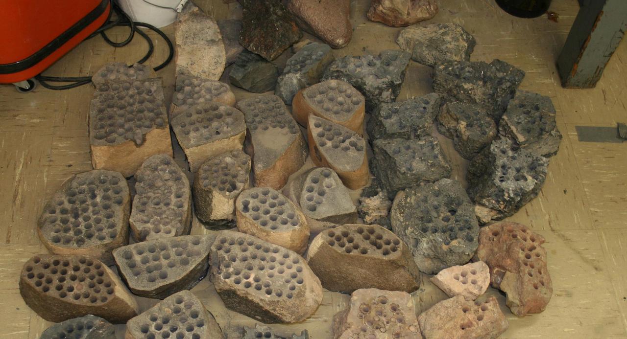 The development of the Mars rover Curiosity capabilities for drilling into a rock on Mars required years of development work. Seen here are some of the rocks used in bit development testing and lifespan testing at JPL in 2007.