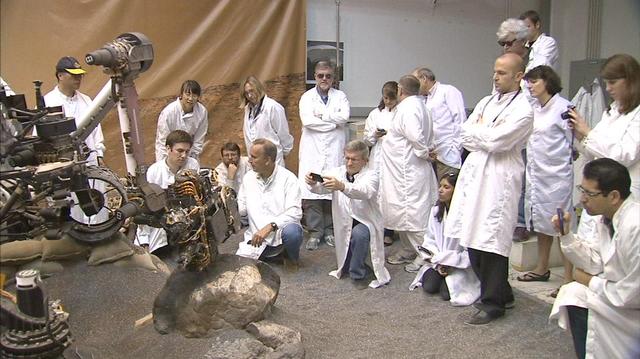 This frame from a video clip shows moments during a demonstration of drilling into a rock at NASA JPL, Pasadena, Calif., with a test double of the Mars rover Curiosity. The drill combines hammering and rotation motions of the bit.