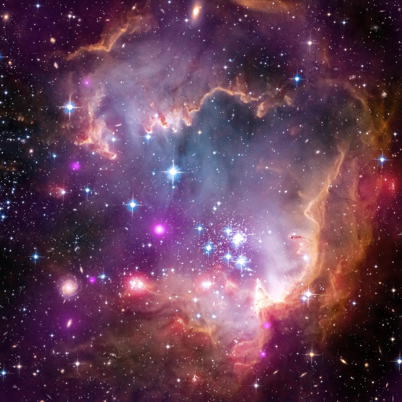 The tip of the wing of the Small Magellanic Cloud galaxy is dazzling in this new view from NASA Great Observatories. The SMC, is a small galaxy about 200,000 light-years way that orbits our own Milky Way spiral galaxy.