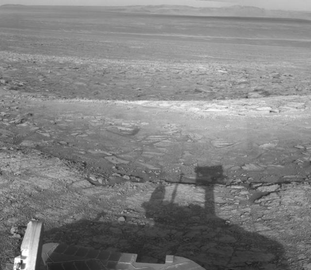 NASA Mars Exploration Rover Opportunity used its navigation camera to record this vista looking eastward across Endeavour Crater, with the rover own shadow in the foreground.