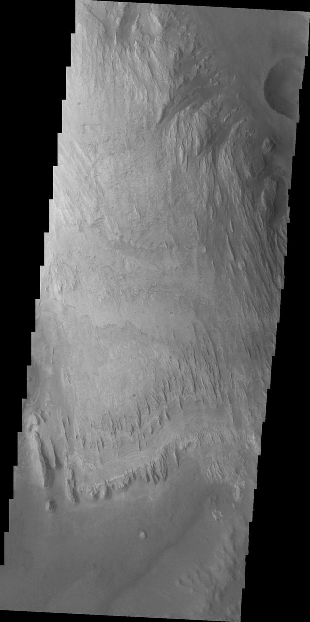 We now begin a traverse across Mt. Sharp moving from east to west. The layering of the material that comprises Mt. Sharp is visible in the bottom third of this image from NASA Mars Odyssey spacecraft; showing the weathering that has affected Mt. Sharp.