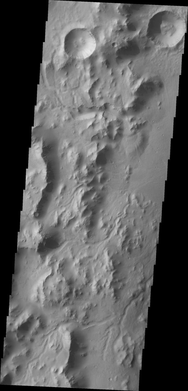 This image from NASA Mars Odyssey spacecraft shows the western rim of Gale Crater. Several channels dissect the rim of the crater.