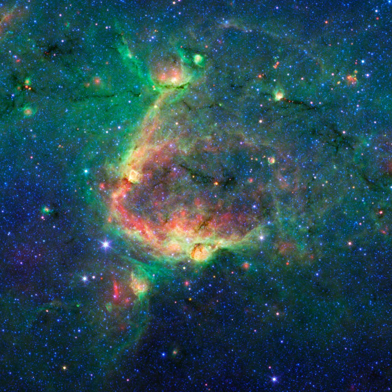 This infrared image from NASA Spitzer Space Telescope shows a striking example of what is called a hierarchical bubble structure, in which one giant bubble, carved into the dust of space by massive stars, has triggered the formation of smaller bubbles.