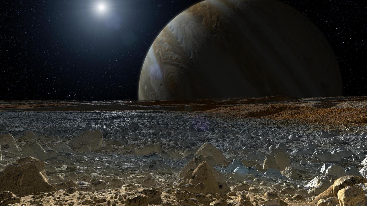 This artist concept shows a simulated view from the surface of Jupiter moon Europa. Europa potentially rough, icy surface, tinged with reddish areas that scientists hope to learn more about.