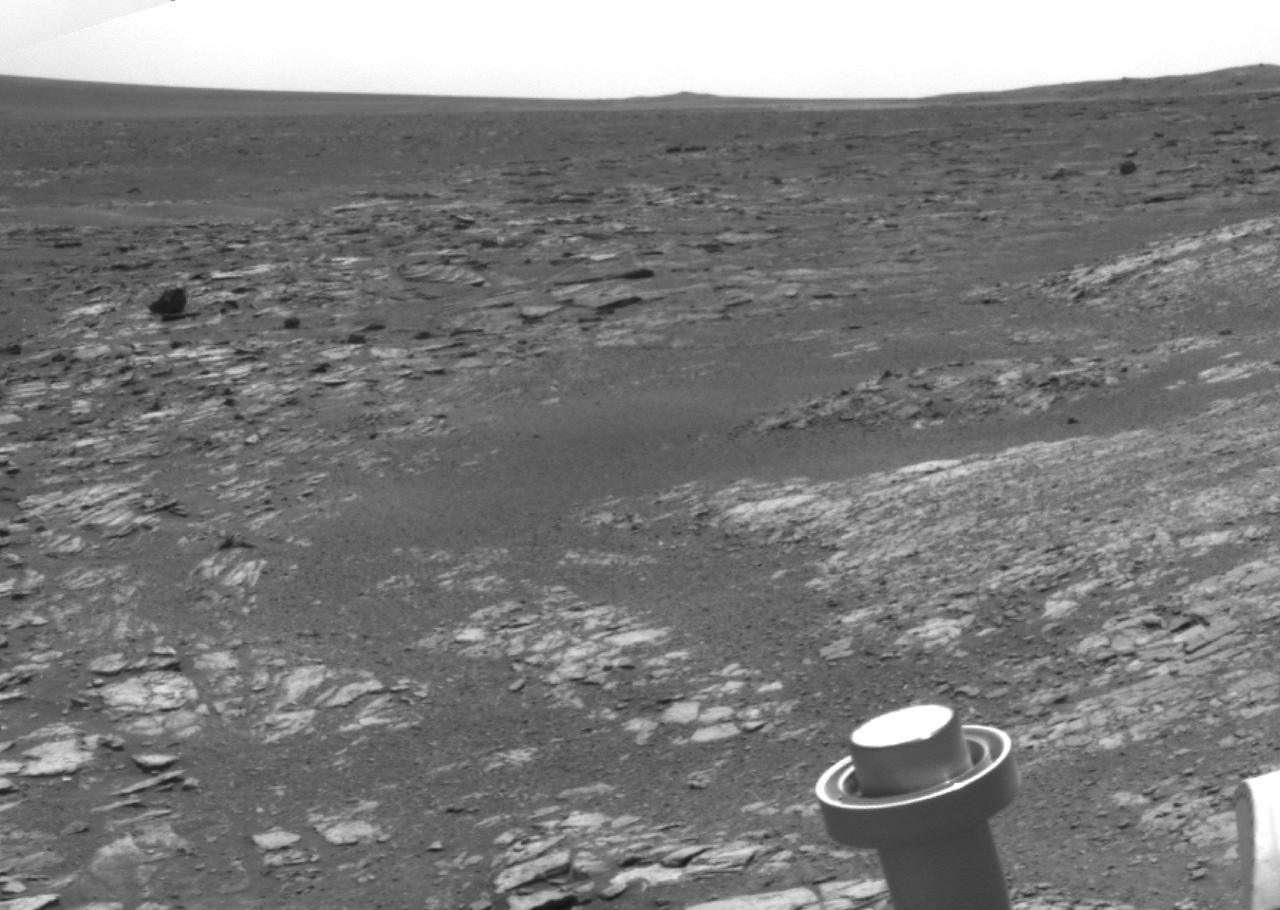 NASA Mars Exploration Rover Opportunity used its navigation camera to acquire this view looking toward the southwest. The scene includes tilted rocks at the edge of a bench surrounding Cape York, with Burns formation rocks exposed in Botany Bay.