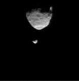 This frame from a movie clip shows the larger of Mars two moons, Phobos, passing in front of the smaller Martian moon, Deimos, as observed by NASA Mars rover Curiosity.