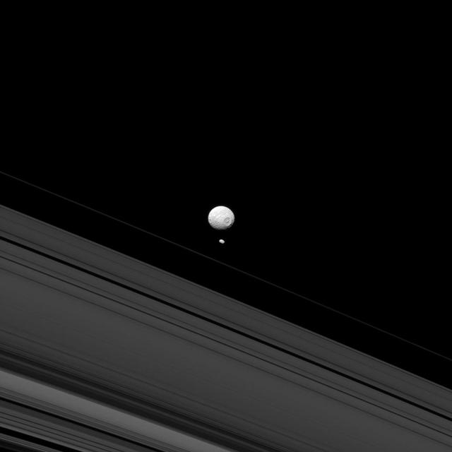 This image from NASA Cassini spacecraft reminds us of how different Mimas and Pandora are when they appear together; although both are moons of Saturn, Pandora small size means that it lacks sufficient gravity to pull itself into a round shape.