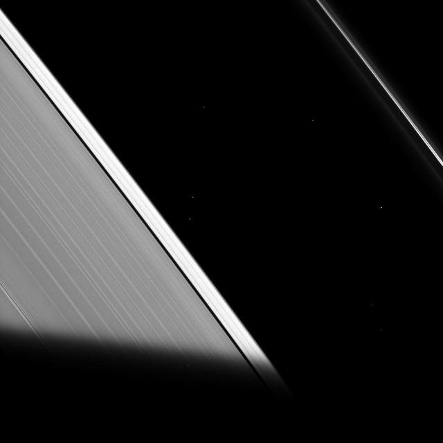 The shadow of Saturn cuts across the rings as seen by NASA Cassini spacecraft. As the ring particles enter Saturn shadow, their temperature drops to even colder temperatures, only to warm back up again when they re-emerge into the sunlight.