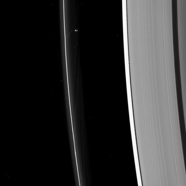 Prometheus, seen here by NASA Cassini spacecraft, sculpting the F ring while Daphnis too small to discern in this image raises waves on the edges of the Encke gap.