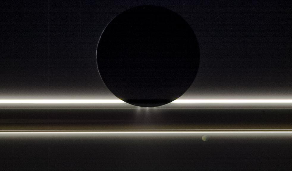Saturn's moon Enceladus drifts before the rings and the tiny moon Pandora in this view captured by NASA's Cassini spacecraft on Nov. 1, 2009. The entire scene is backlit by the Sun, providing striking illumination for the icy particles that make up both the rings and the jets emanating from the south pole of Enceladus, which is about 314 miles (505 km) across. Pandora, which is about (52 miles, 84 kilometers) wide, was on the opposite side of the rings from Cassini and Enceladus when the image was taken. This view looks toward the night side on Pandora as well, which is lit by dim golden light reflected from Saturn.  This natural-color image was taken in visible light with the Cassini spacecraft's narrow-angle camera at a distance of approximately 149,600 miles (240,800 kilometers) from Enceladus and 352,200 miles (566,800 kilometers) from Pandora.  The Cassini spacecraft ended its mission on Sept. 15, 2017.  https://photojournal.jpl.nasa.gov/catalog/PIA17144