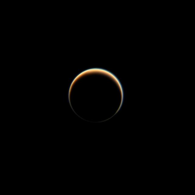 NASA's Cassini spacecraft looks towards the dark side of Saturn's largest moon, Titan, capturing the blue halo caused by a haze layer that hovers high in the moon's atmosphere. The haze that permeates Titan's atmosphere scatters sunlight and produces the orange color seen here. More on Titan's orange and blue hazes can be found at PIA14913. This view looks towards the side of Titan (3,200 miles or 5,150 kilometers across) that leads in its orbit around Saturn. North on Titan is up and rotated 40 degrees to the left. Images taken using red, green and blue spectral filters were combined to create this natural-color view. The images were taken with the Cassini spacecraft narrow-angle camera on Nov. 3, 2013. The view was acquired at a distance of approximately 2.421 million miles (3.896 million kilometers) from Titan. Image scale is 14 miles (23 kilometers) per pixel. http://photojournal.jpl.nasa.gov/catalog/PIA17180