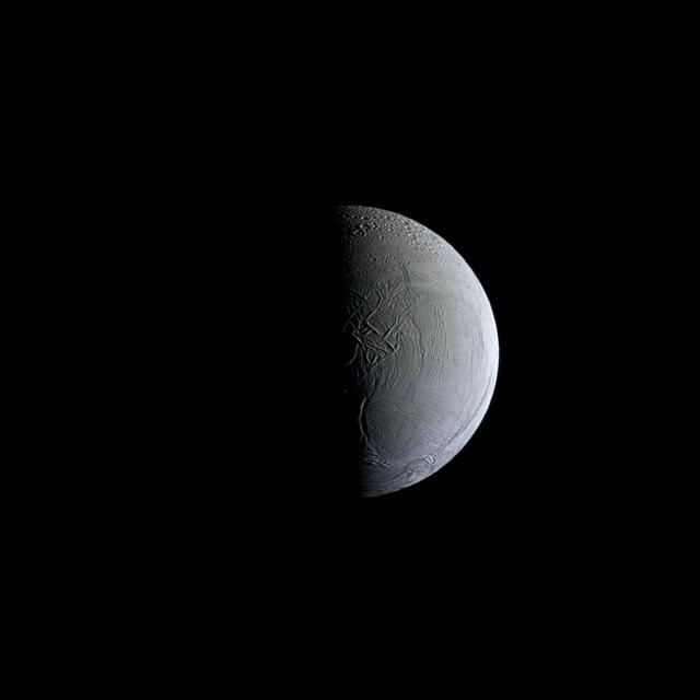 NASA Cassini spacecraft captures a still and partially sunlit Enceladus. The Saturnian moon is covered in ice that reflects sunlight similar to freshly fallen snow, making Enceladus one of the most reflective objects in the solar system.