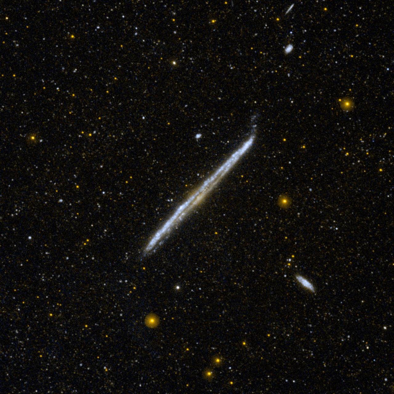 This image from NASA Galaxy Evolution Explorer shows NGC 4565, one of the nearest and brightest galaxies not included in the famous list by 18th-century comet hunter Charles Messier.