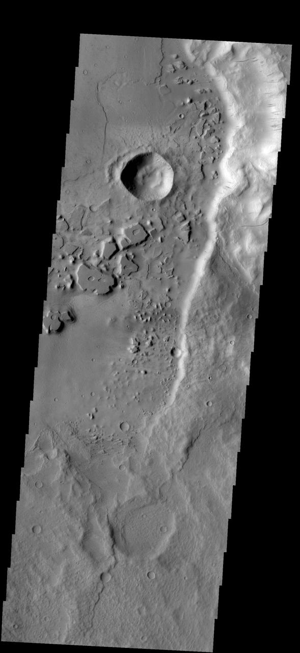 Dark streaks mark the steep slopes of this ridge located east of Mangala Valles as seen by NASA 2001 Mars Odyssey spacecraft.