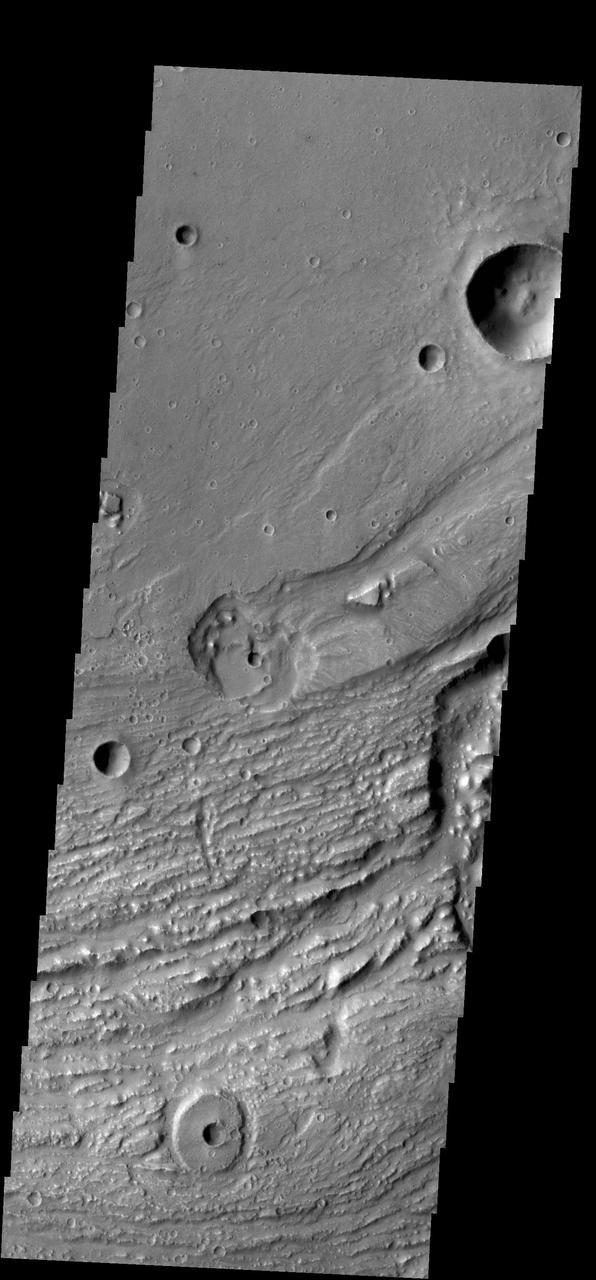 This image shows another portion of Ravi Vallis. In this image taken by NASA 2001 Mars Odyssey spacecraft, a small crater and the resistant material formed during the impact form a donut on the floor of the valley.