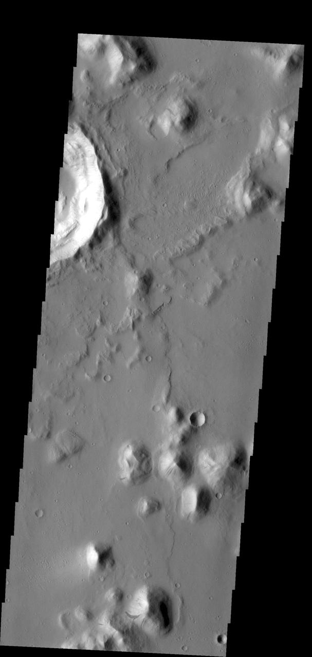 The small hill in this image aptured by NASA 2001 Mars Odyssey spacecraft of Amazonis Planitia has several dark slope streaks, believed to form when down slope movement of rocks or other debris clear off some of the dust cover.