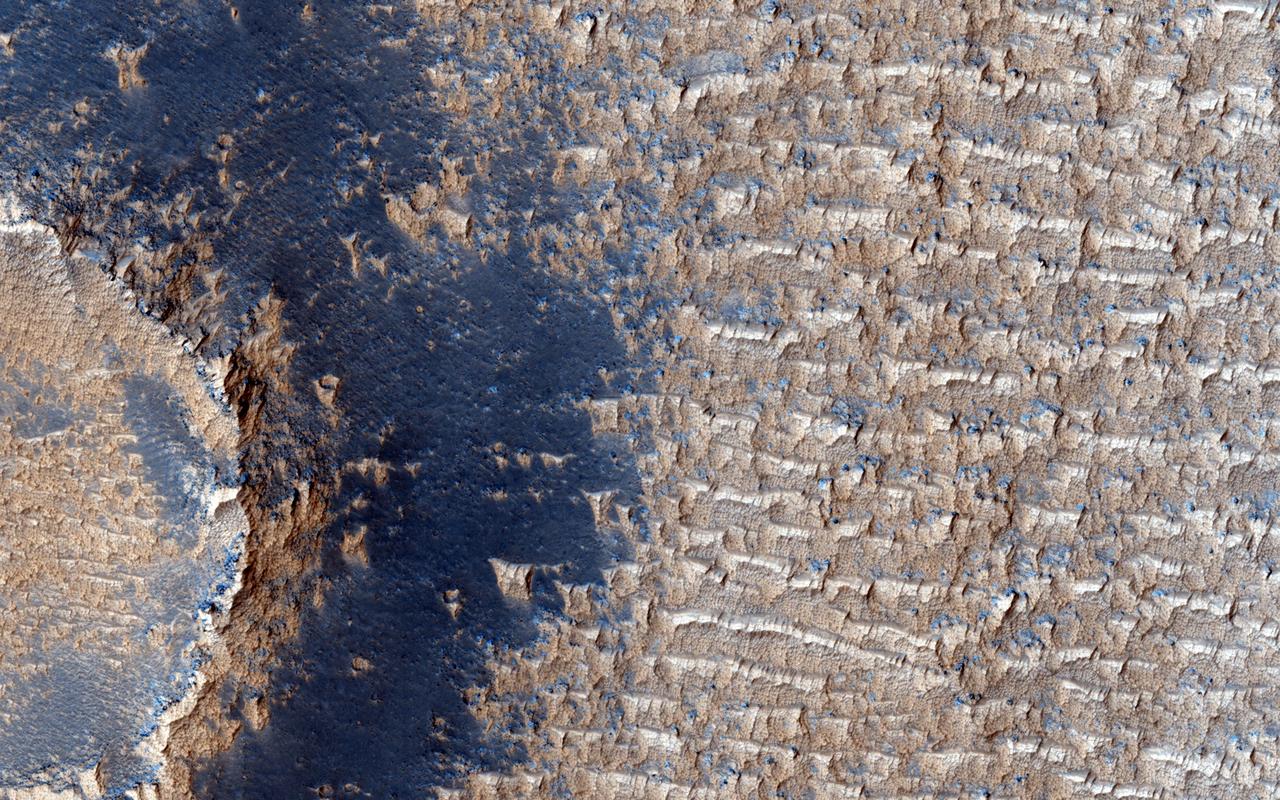 This image from NASA Mars Reconnaissance Orbiter shows curious bright deposits in Syria Planum, a high elevation region near the summit of the Tharsis rise.