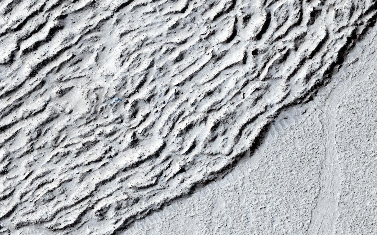 This image shows lava crumpled against the upstream side of an impact crater as seen by NASA Mars Reconnaissance Orbiter.
