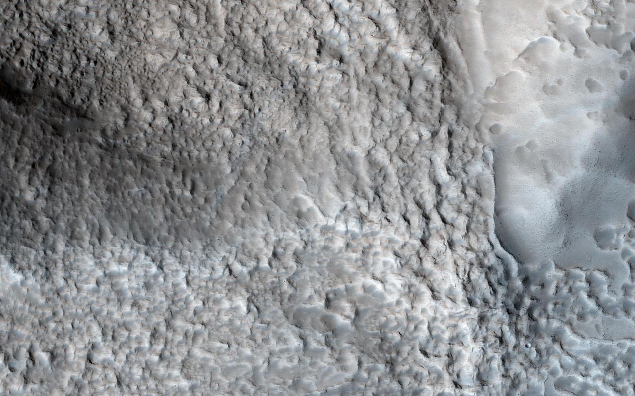 This image from NASA Mars Reconnaissance Orbiter shows an impact crater with a diameter of approximately 2 kilometers located in the Coloe Fossae region of Mars.