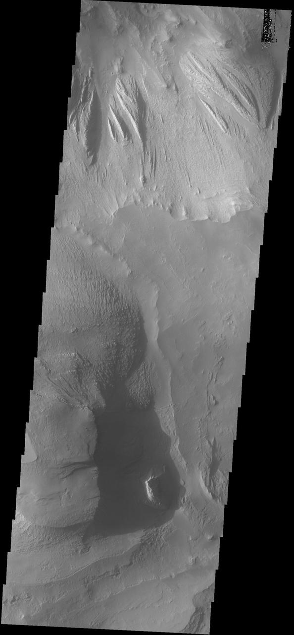 Shadows cast by the high walls and high hills within Candor Chasma are visible in this image from NASA 2001 Mars Odyssey spacecraft. The local time is near 5:00 in the afternoon.