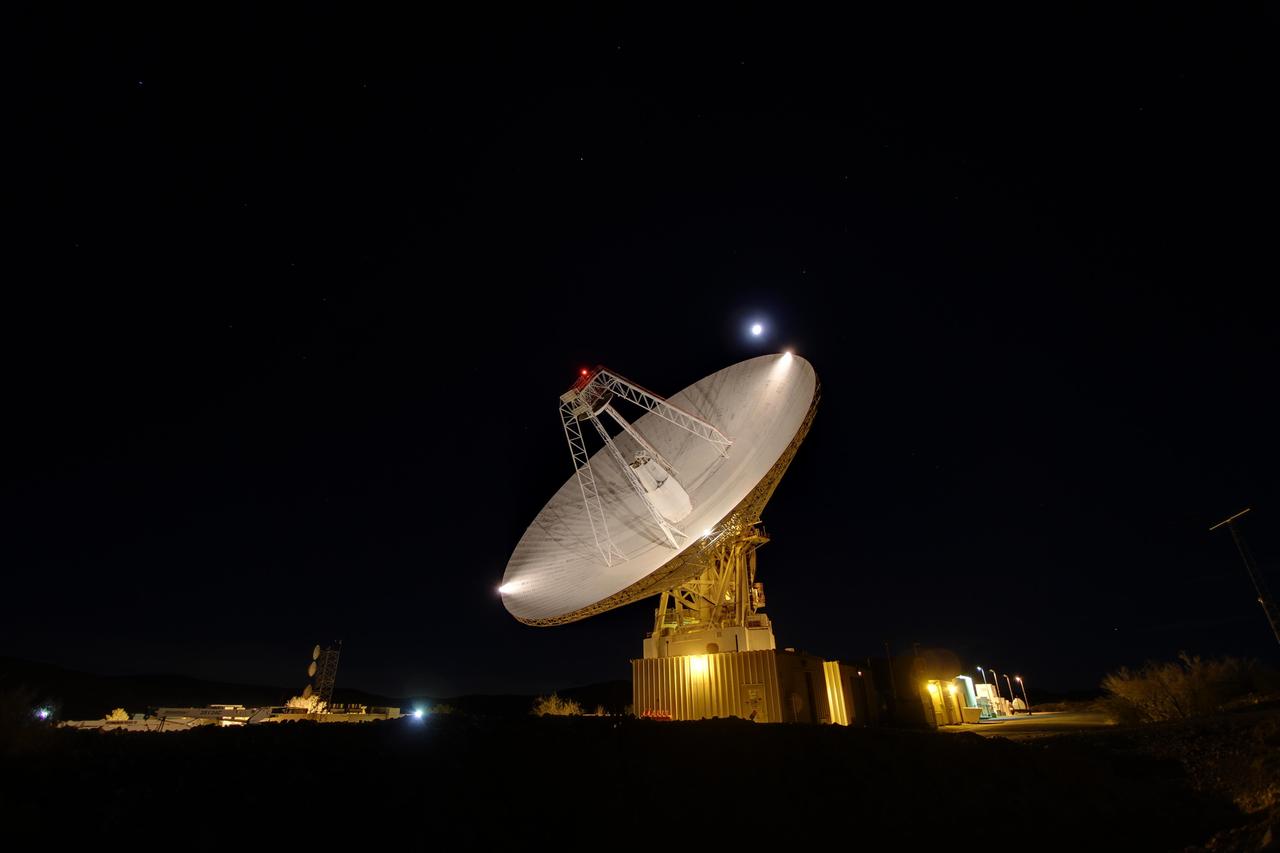 Goldstone 230-foot 70-m antenna tracks under a full moon. The Goldstone Deep Space Communications Complex is located in the Mojave Desert in California, USA.