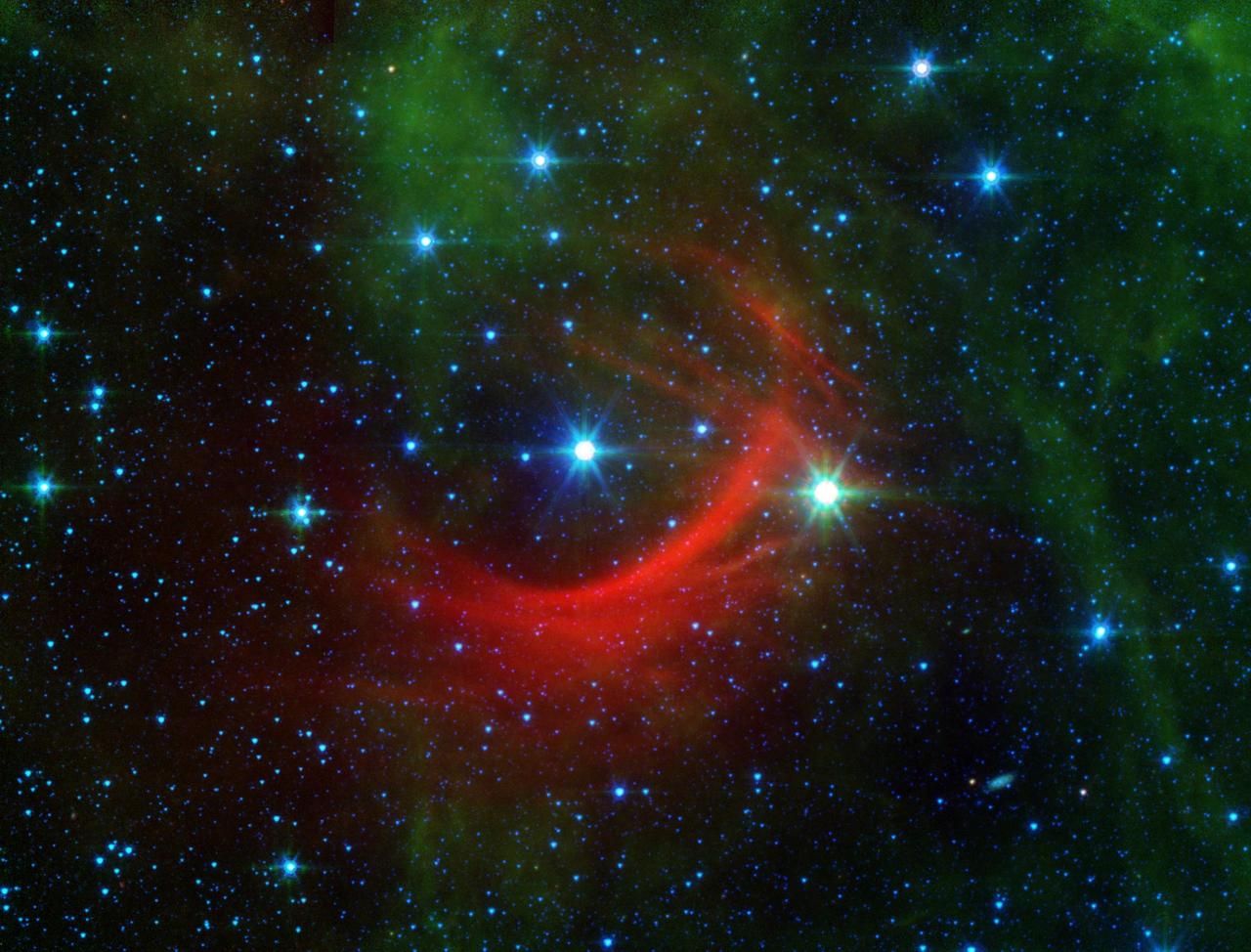 The red arc in this infrared image from NASA Spitzer Space Telescope is a giant shock wave, created by a speeding star known as Kappa Cassiopeiae.