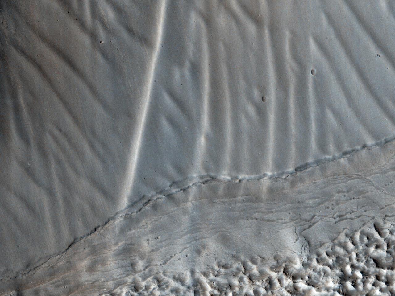 This observation from NASA Mars Reconnaissance Orbiter shows a set of landforms that appears to form a nested chevron pattern on a slope in Coloe Fossae. Interestingly, nearby surfaces on the same slope are all parallel.