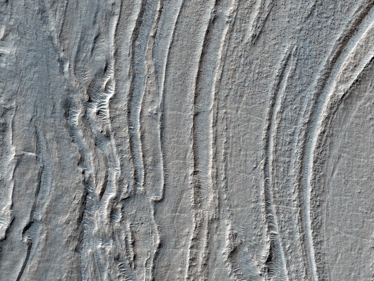 Low lying areas in the Hellas region, which is the largest impact basin on Mars, often show complex groups of banded ridges, furrows, and pits as seen in this observation from NASA Mars Reconnaissance Orbiter.