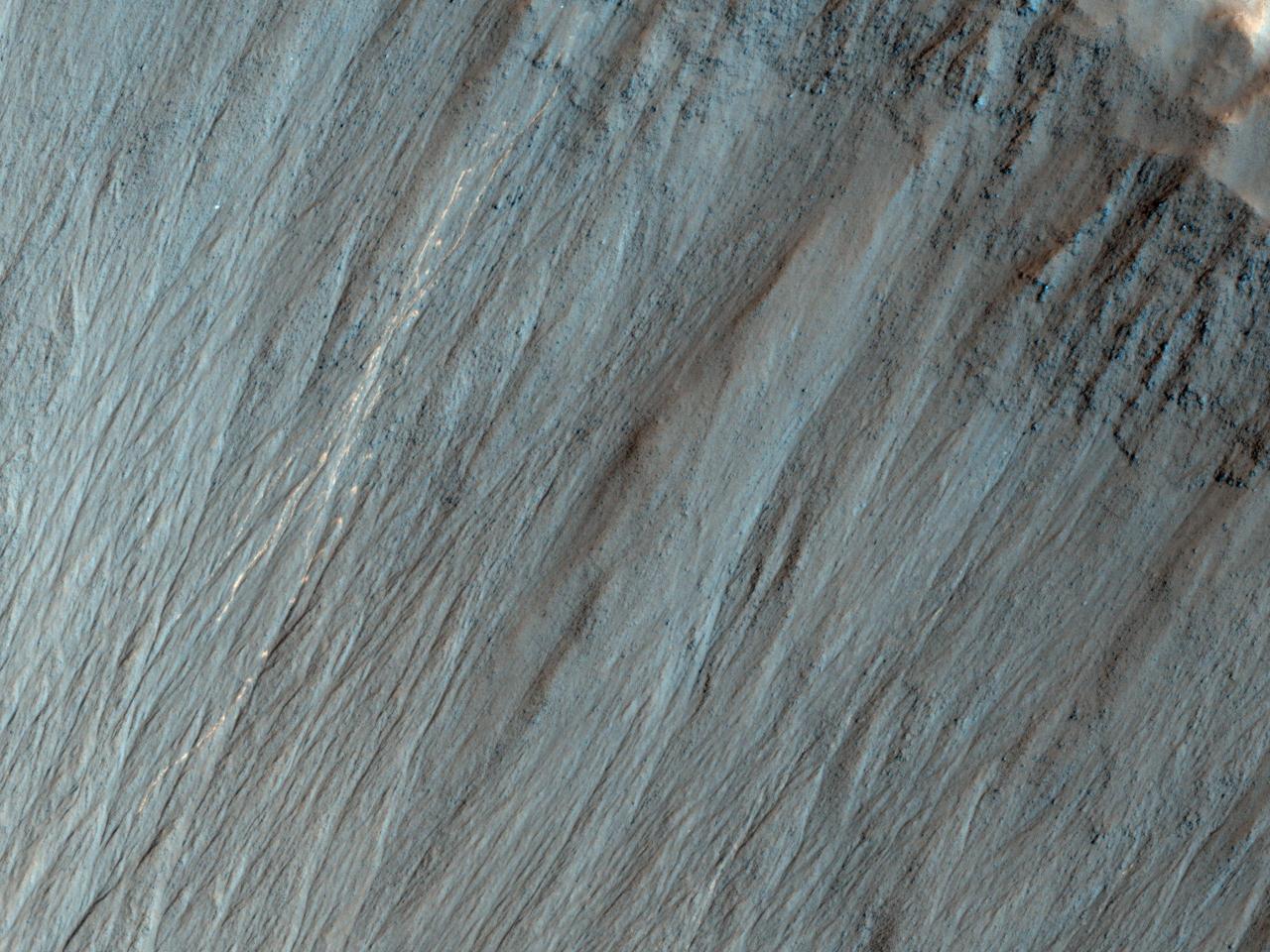 This image from NASA Mars Reconnaissance Orbiter shows a well-preserved impact crater. A closeup view highlights distinctive bright lines and spots on the steep slope on the north side.