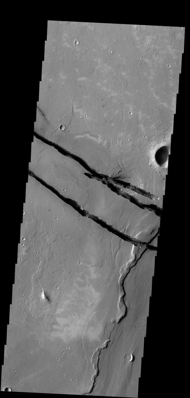 The fractures in this image are part of a large system of fractures called Cerberus Fossae. Athabasca Valles is visible in the lower right corner of the image as seen by NASA 2001 Mars Odyssey spacecraft.