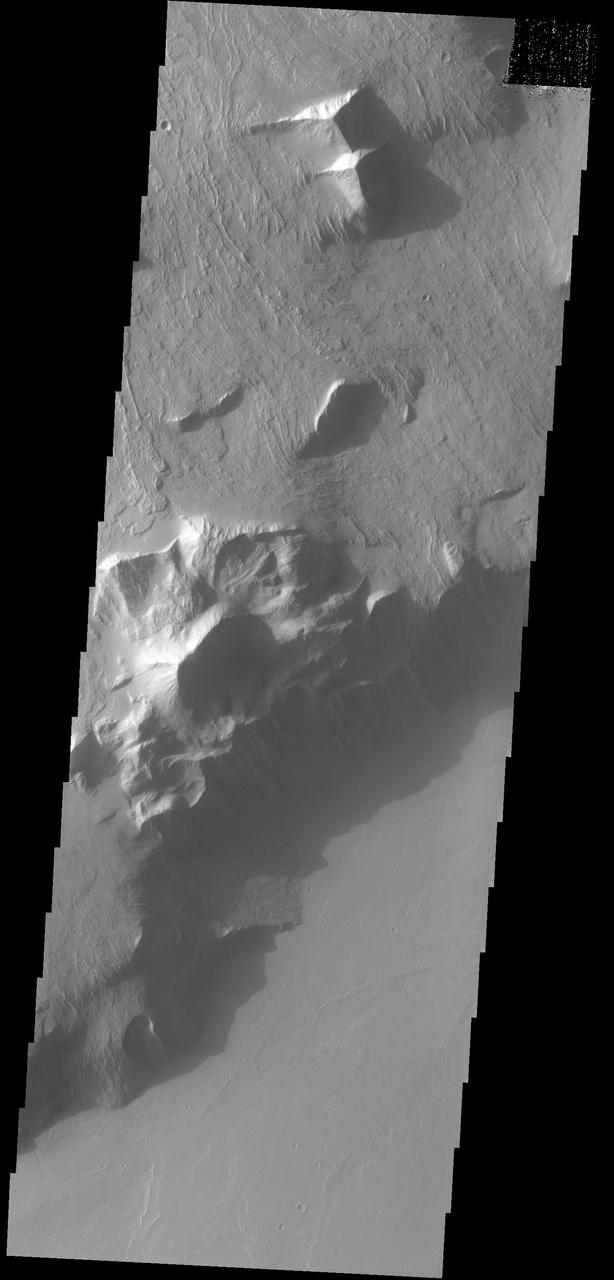 This image captured by NASA 2001 Mars Odyssey spacecraft shows part of the escarpment that encircles Olympus Mons. This image is located on the southeastern flank of the volcano.
